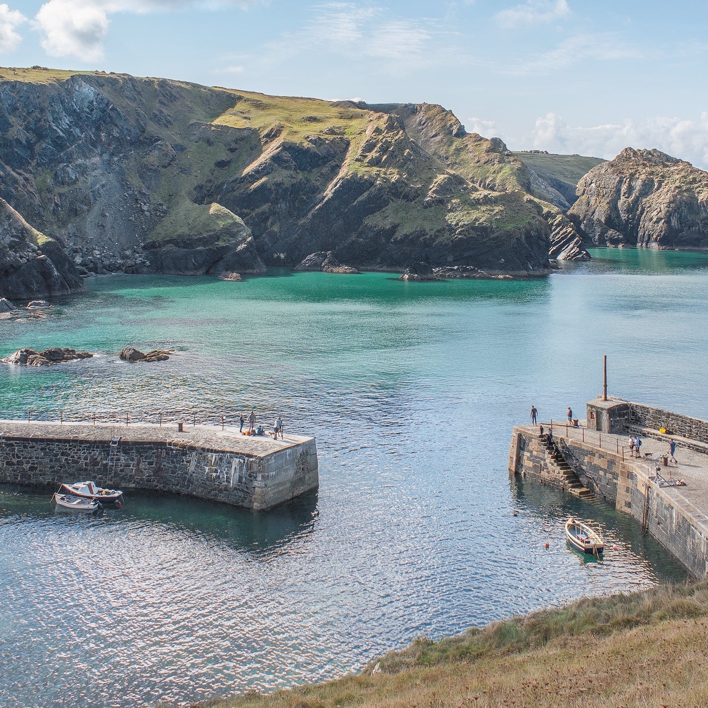 Mullion cover, with harbour walls, towering cliffs and turquoise water