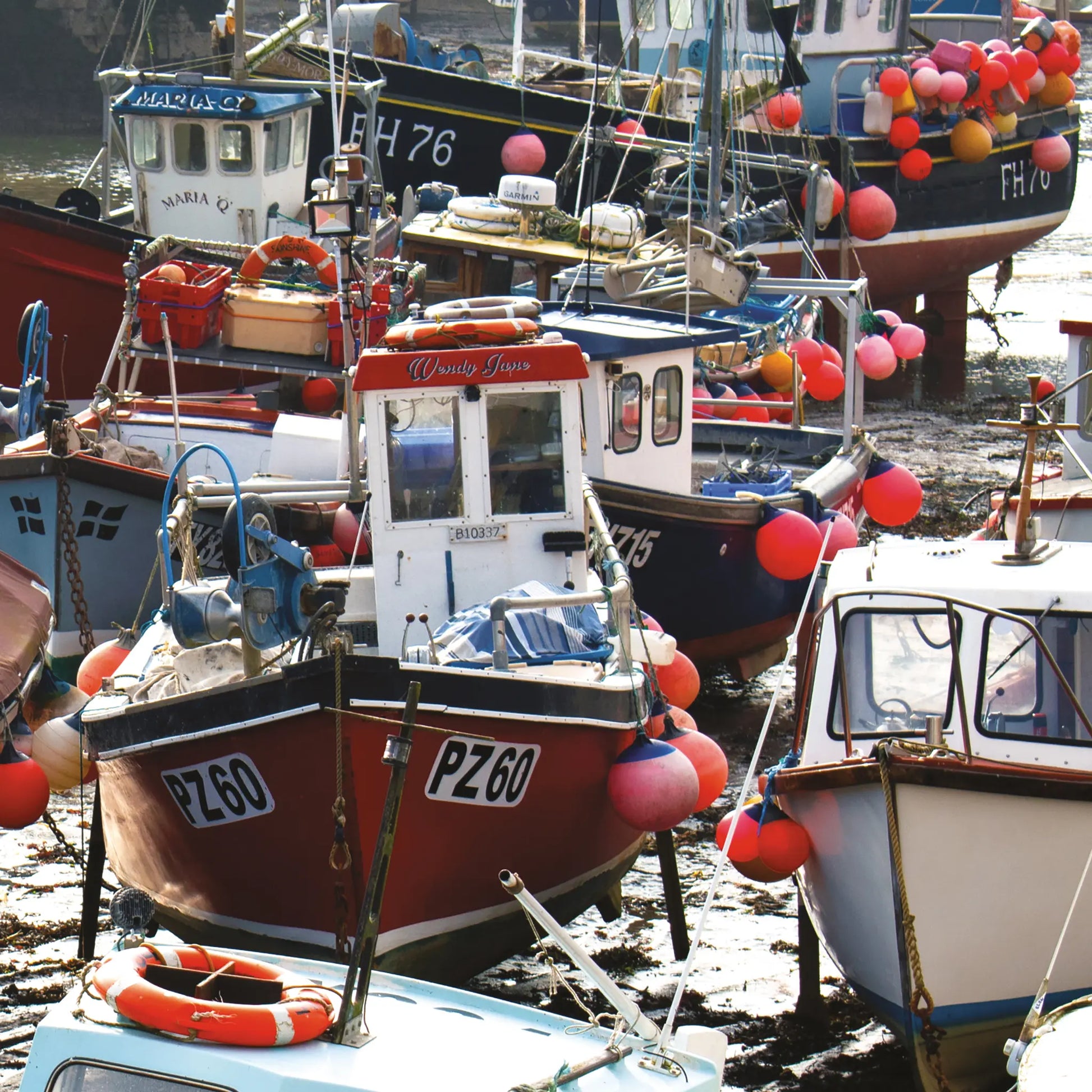 Cornish greetings card image of boats at low tide in Mevagissey Harbour, blues and reds