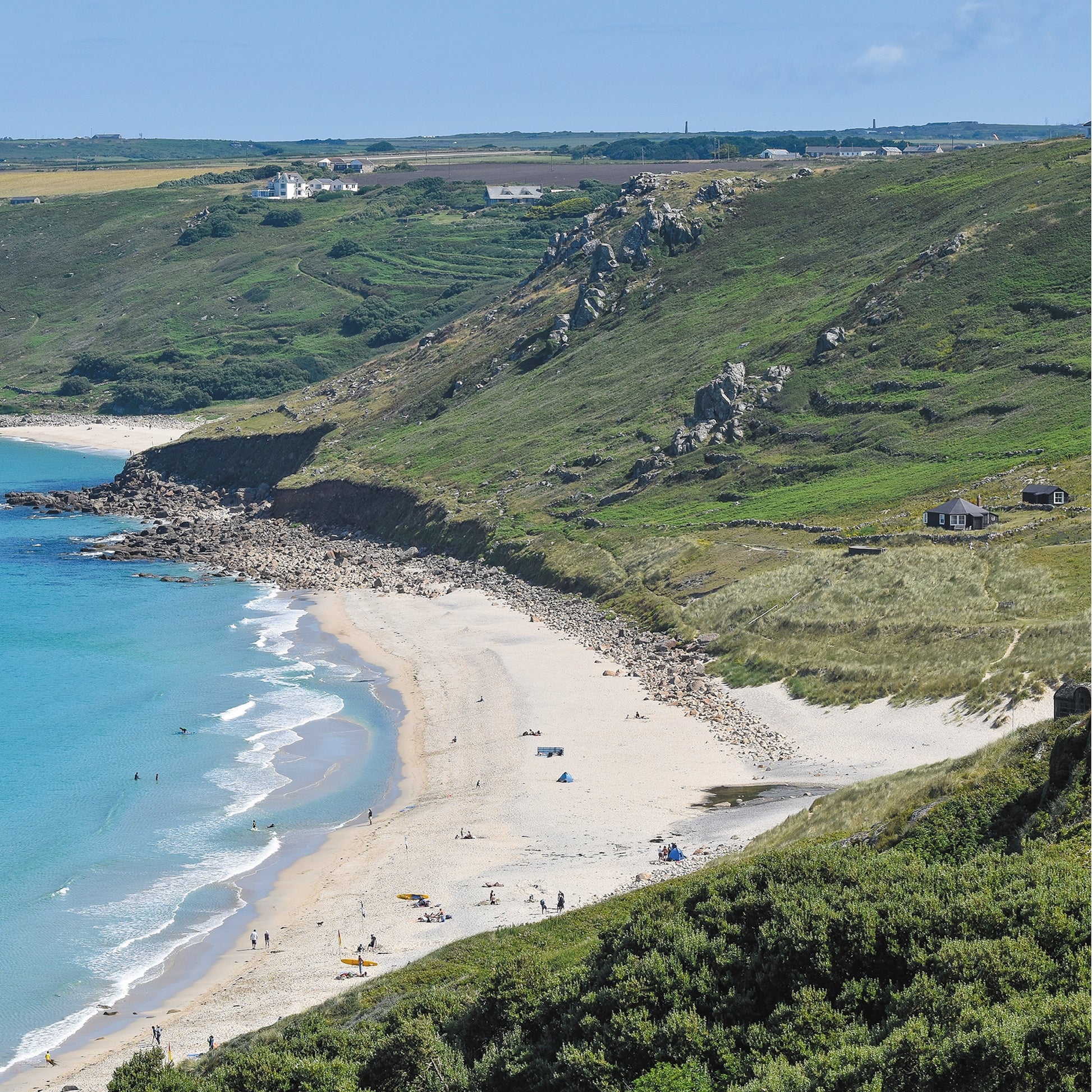 An Evocative Cornwall greetings card image looking down at the white sands and turquoise water of Sennen Beach and the surrounding granite crags of the cliffs, terraced hillside and dunes.