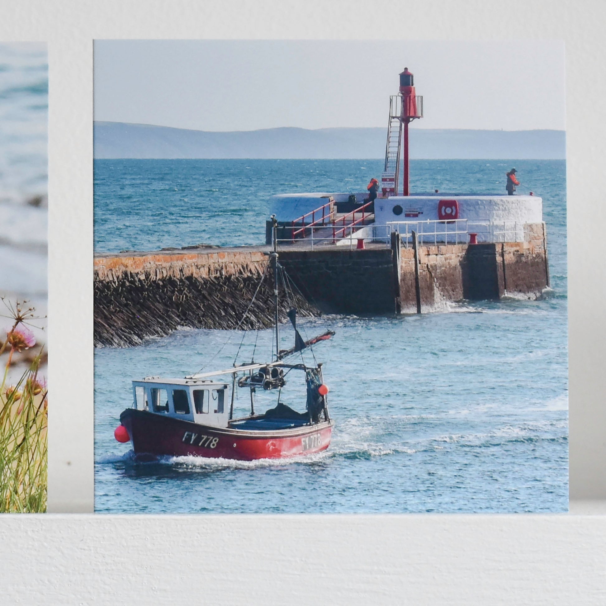 Cornish greetings card showing a red fishing boat passing fishermen on the famous banjo pier