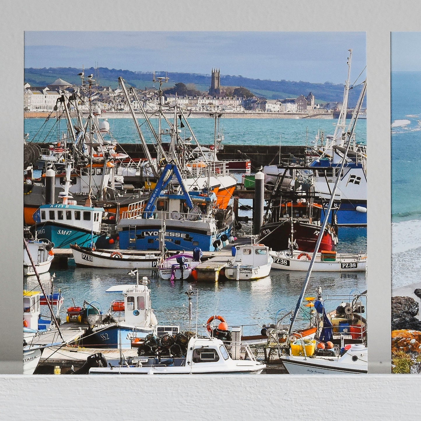 Cornish greetings card showing busy Newlyn harbour with a view of Penzance in the background