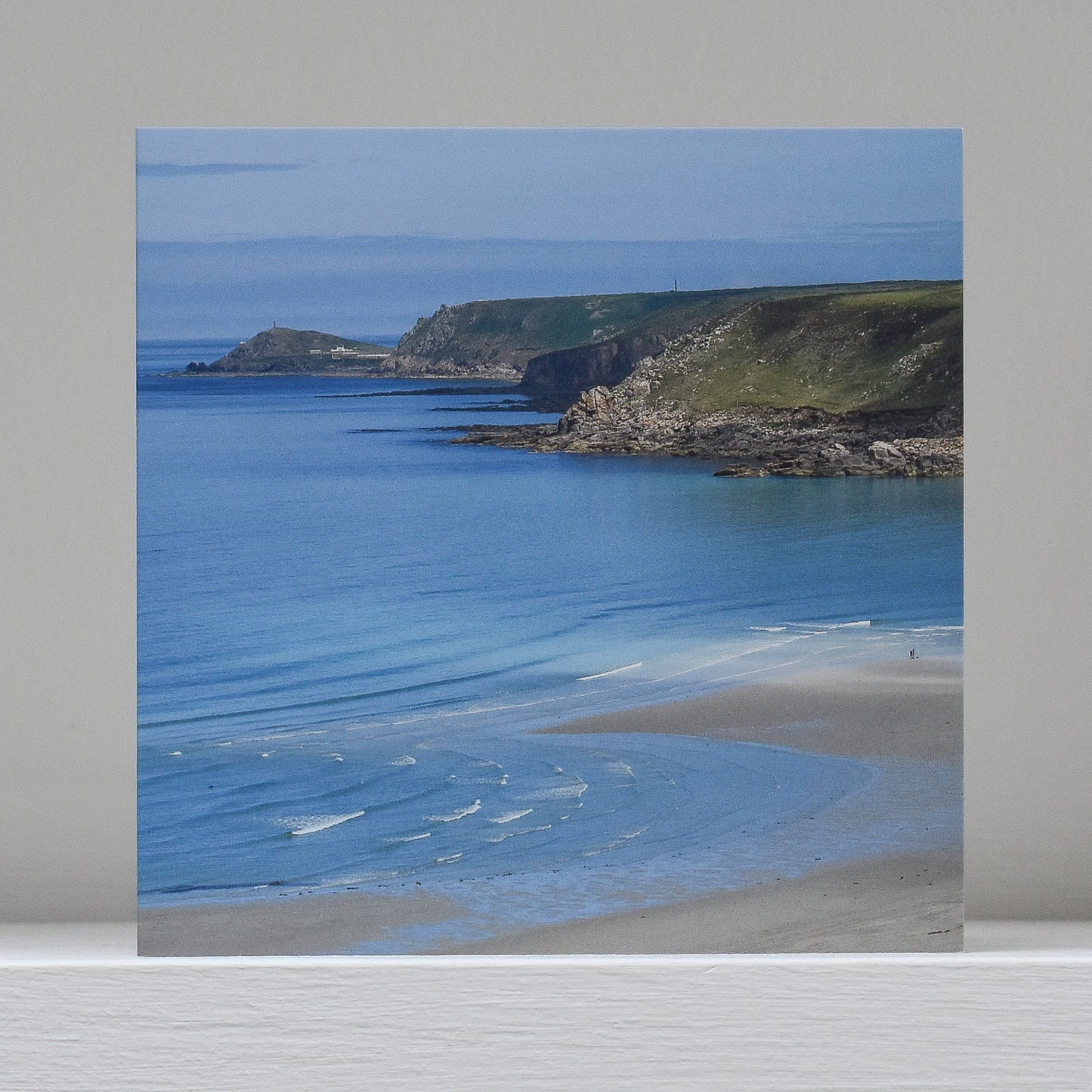 Greetings card on shelf showing image of Whitesands Bay looking towards Cape Cornwall on a beautiful clear blue day