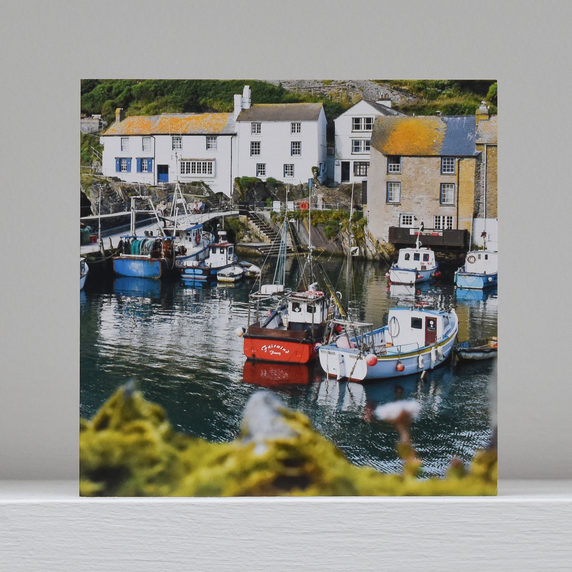 Greetings card on shelf showing image of boats in the harbour at Polperro
