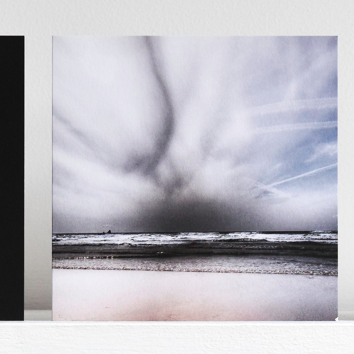 Art card showing moody sky over monchrome waves