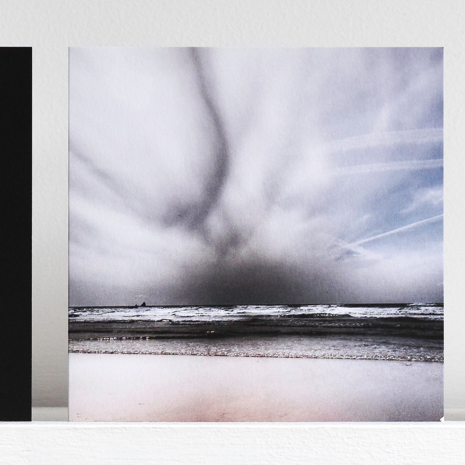 Art card showing moody sky over monchrome waves