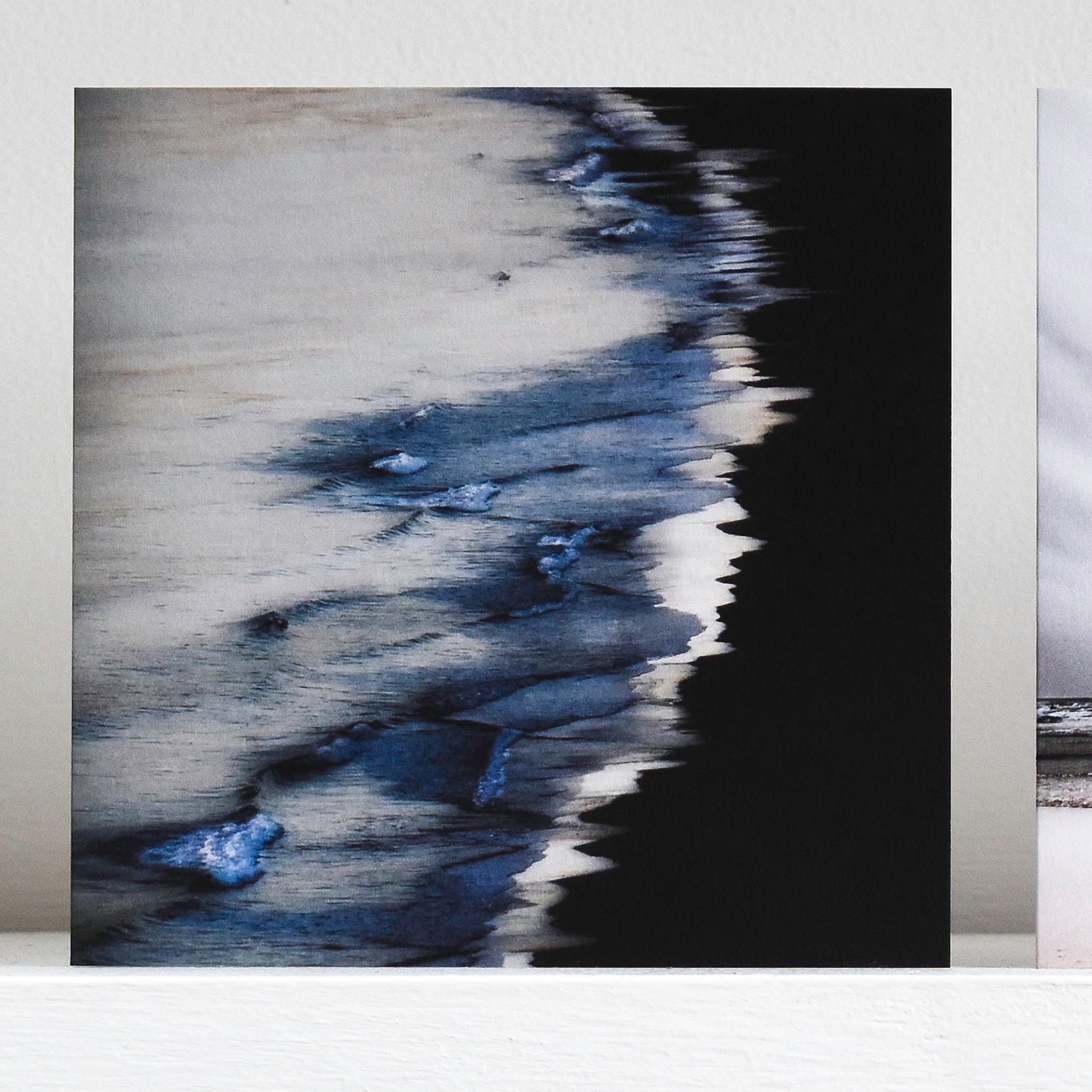 Art card showing indigo waves on a black shore
