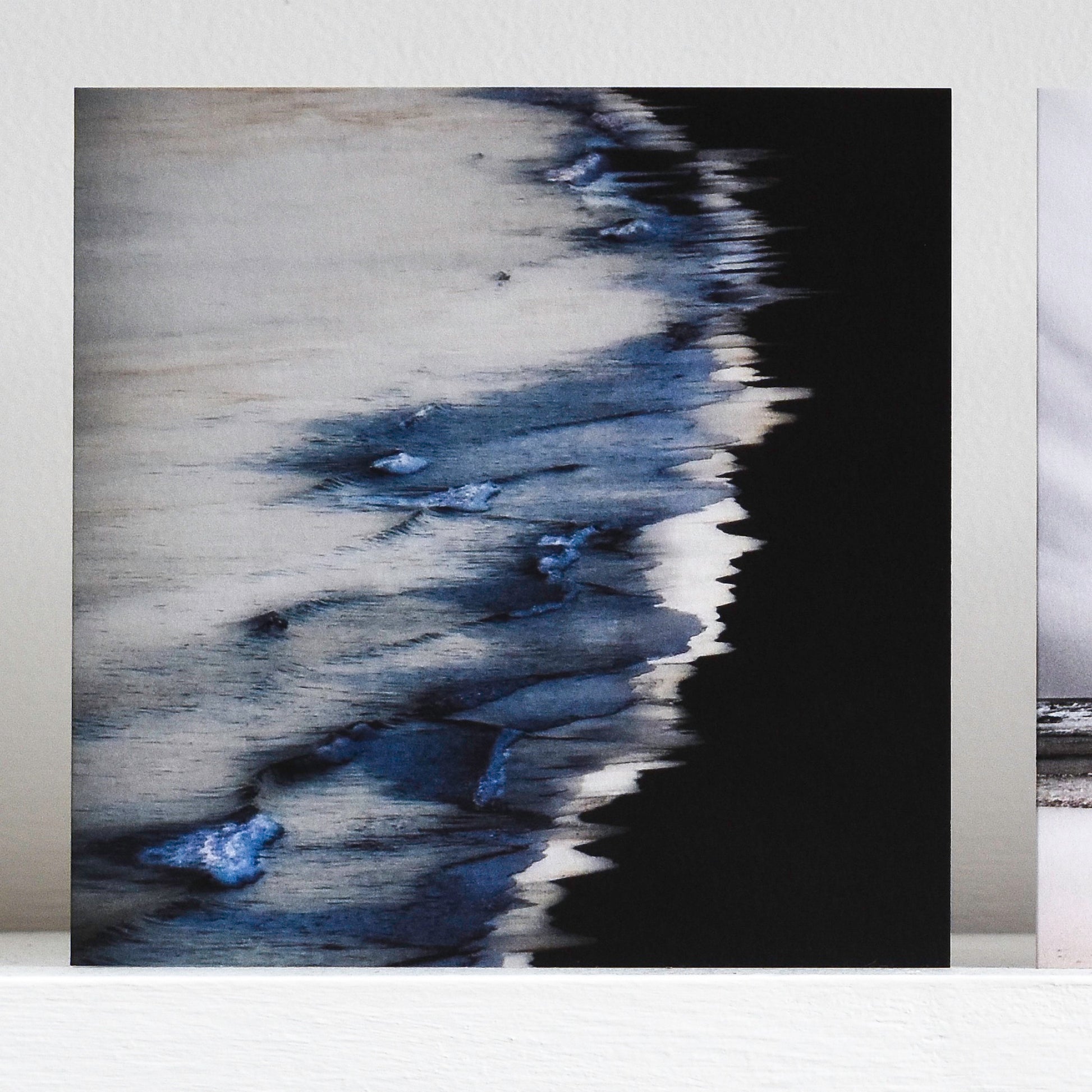 Art card showing indigo waves on a black shore