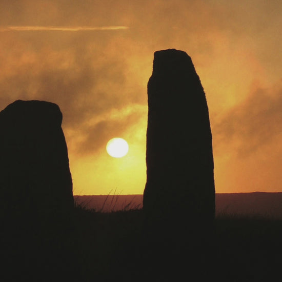 Video animation showing greeting card with sun setting at Nine Maidens stone circle, 3 of the stones in silhouette against an amber sky