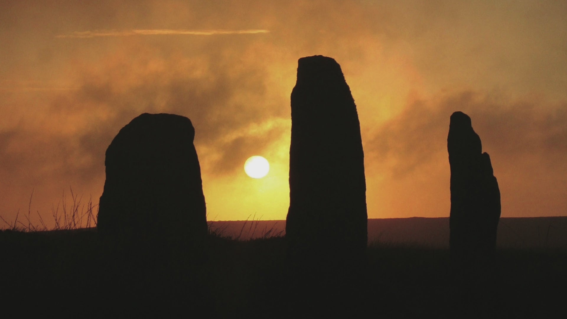 Video animation showing greeting card with sun setting at Nine Maidens stone circle, 3 of the stones in silhouette against an amber sky