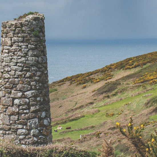 Video animation of greeting card, featuring an old mining stack in West Penwith, with gorse-topped cliffs and the sea in the background, and rain on the horizon